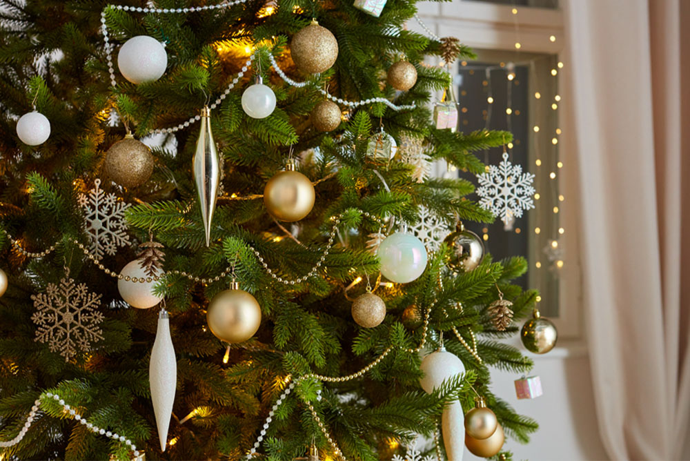 Karácsonyfa arany, ezüst és fehér színű díszekkel.